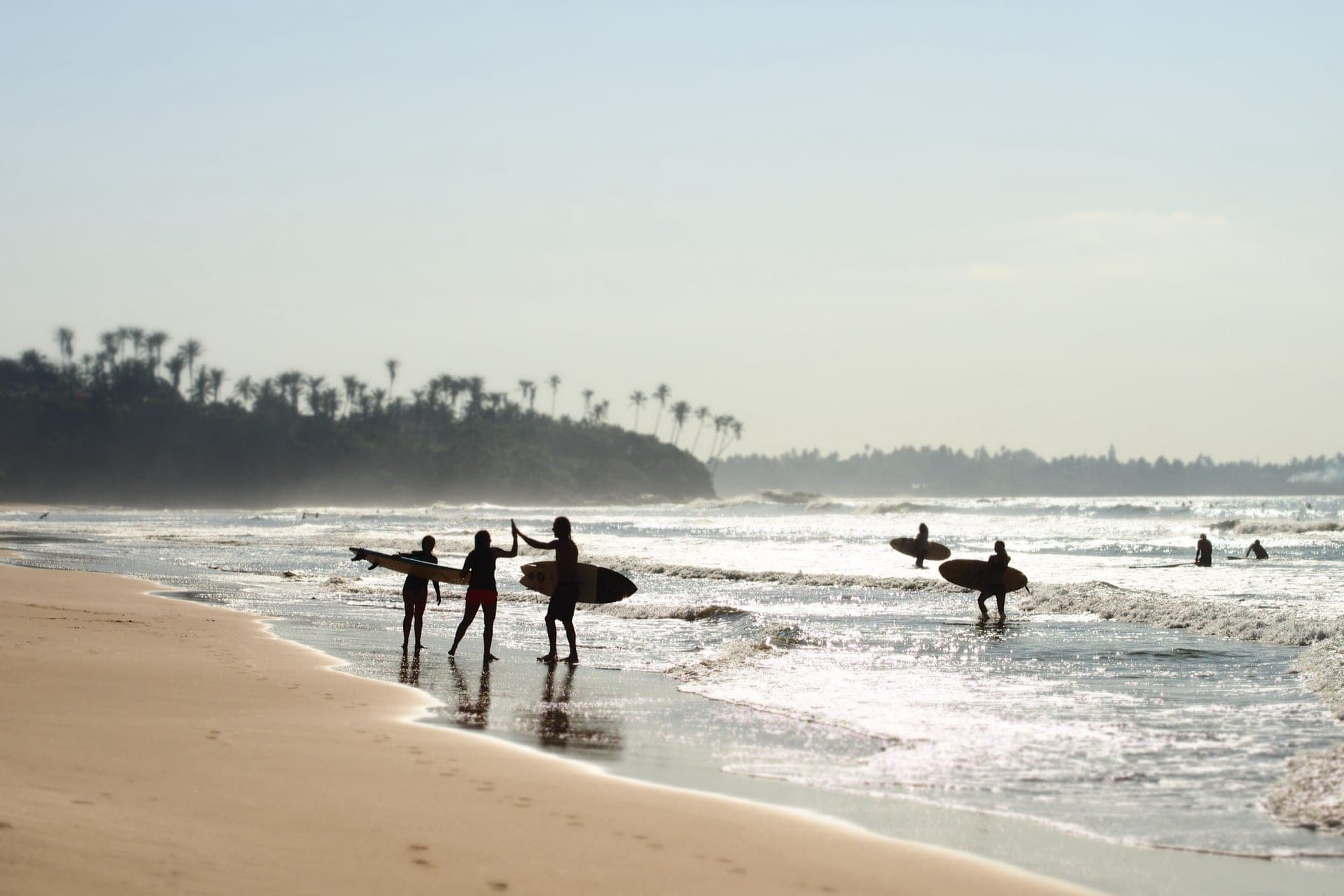 Surfers walking out to the break on the beach in front of The Seascape