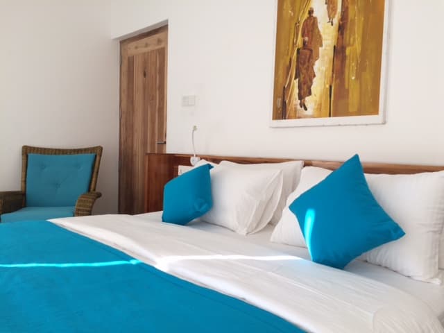 Ground-floor room with teal accents opening onto its terrace